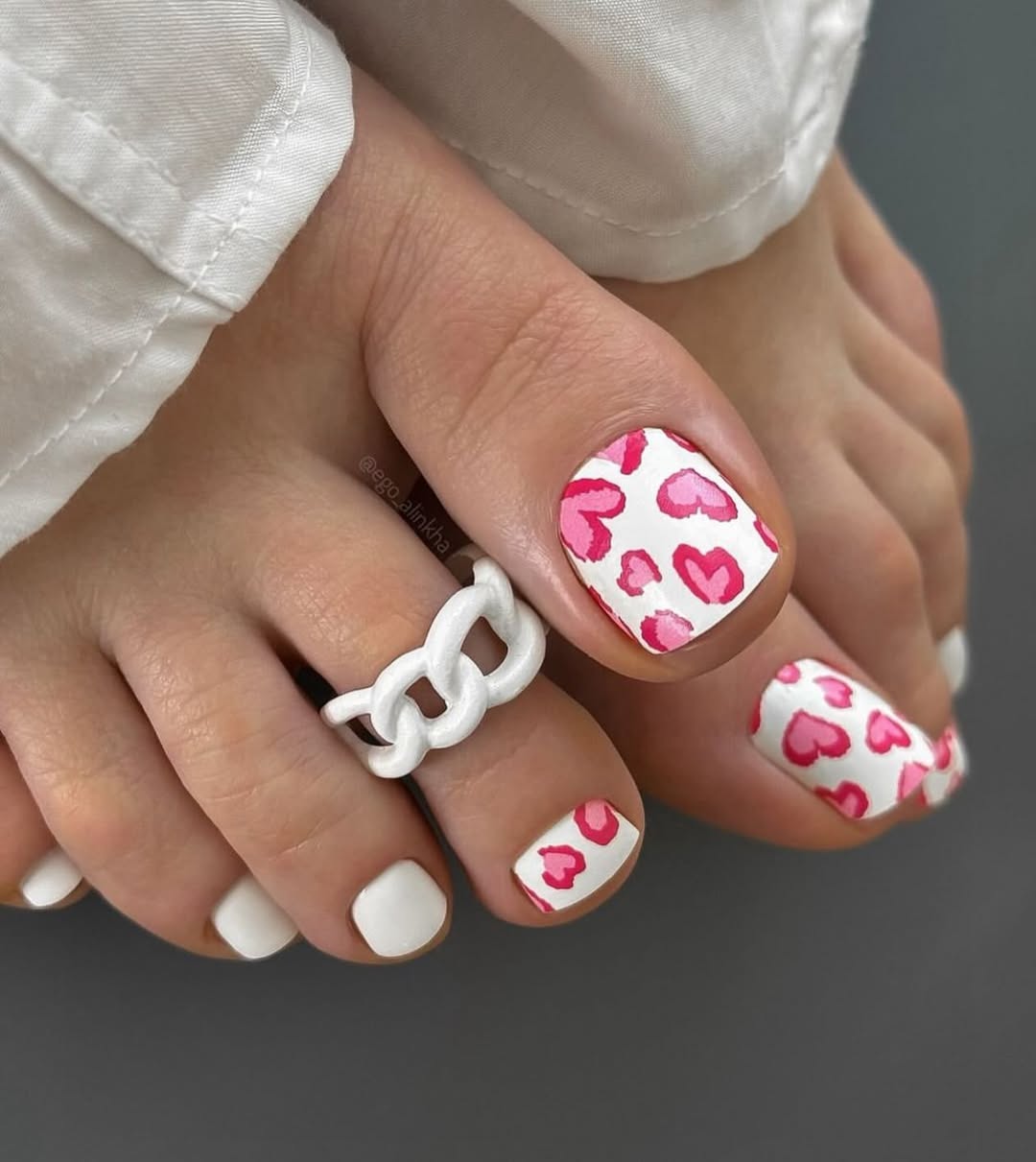 Pedicure w białym kolorze z różowymi serduszkami