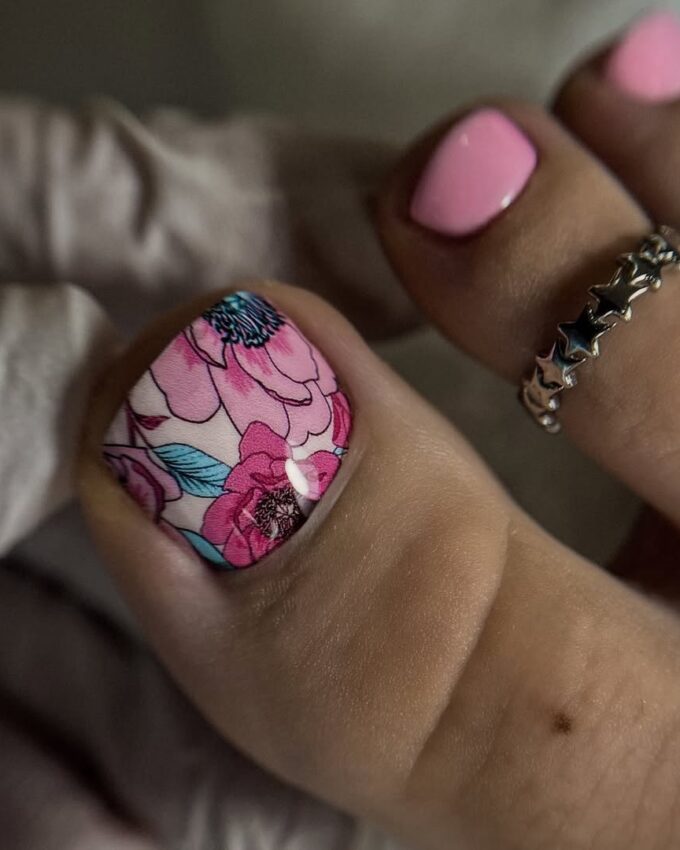 Różowy pedicure z kolorowym kwiatowym wzorem na dużym paznokciu