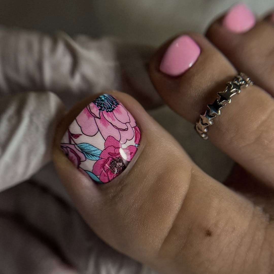 Różowy pedicure z kolorowym kwiatowym wzorem na dużym paznokciu