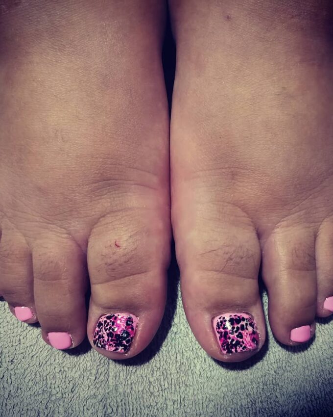 Różowy pedicure z czarnym wzorem przypominającym panterkę na dużym paznokciu